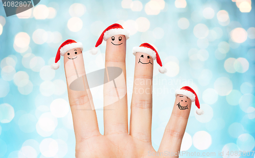 Image of close up of hand with four fingers in santa hats