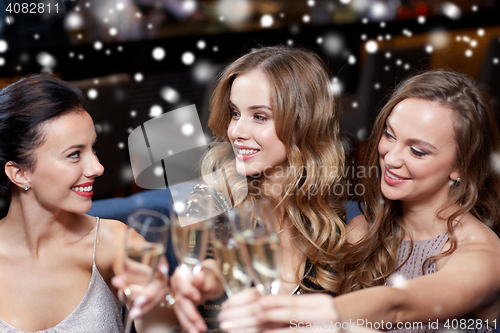 Image of happy women with champagne glasses at night club
