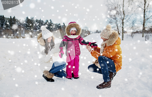 Image of happy family with child in winter clothes outdoors