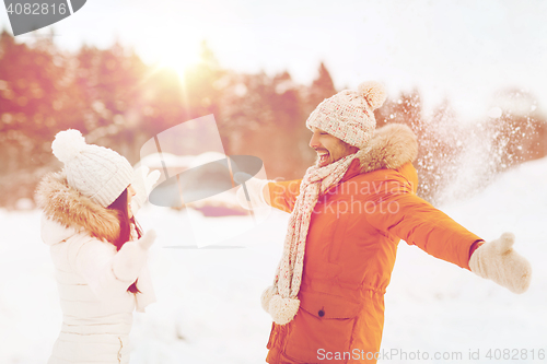Image of happy couple playing with snow in winter