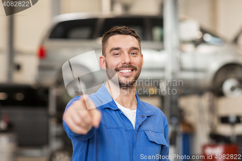 Image of happy auto mechanic man or smith at car workshop
