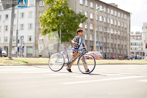 Image of young man with fixed gear bicycle on crosswalk