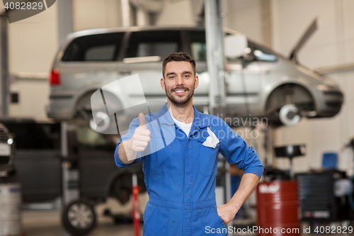 Image of happy auto mechanic man or smith at car workshop