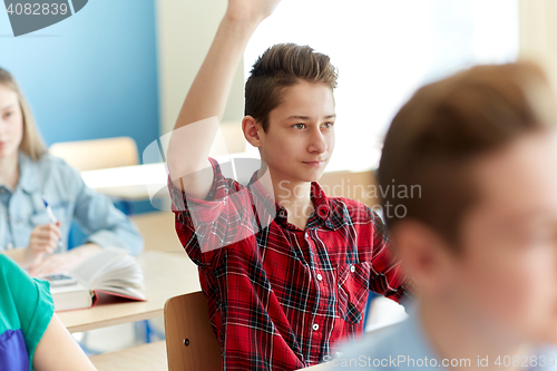 Image of happy student boy raising hand at school lesson