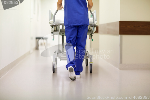 Image of nurse carrying hospital gurney to emergency room