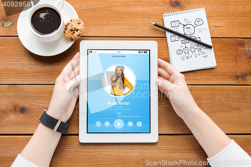 Image of close up of woman with tablet pc on wooden table