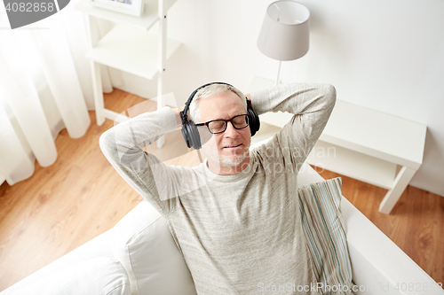 Image of happy man in headphones listening to music at home