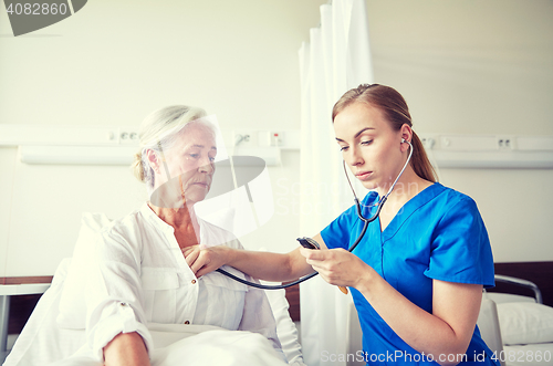 Image of nurse with stethoscope and senior woman at clinic