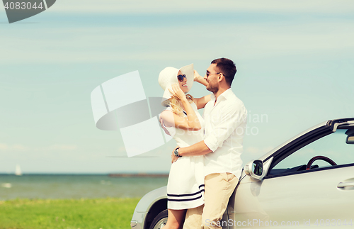 Image of happy man and woman hugging near car at sea