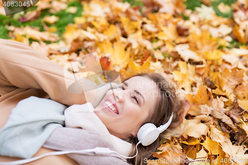 Image of woman with headphones listening to music in autumn