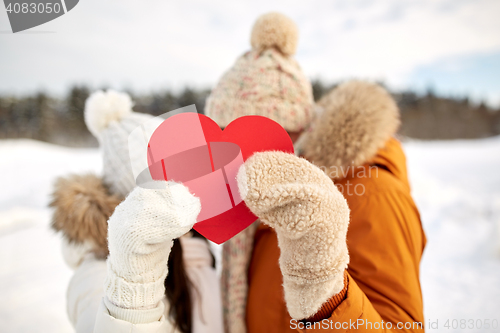 Image of happy couple with red heart over winter landscape