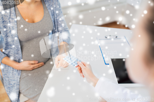 Image of close up of doctor giving pills to pregnant woman