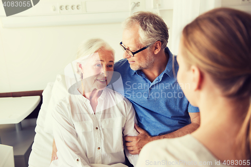 Image of happy family visiting senior woman at hospital