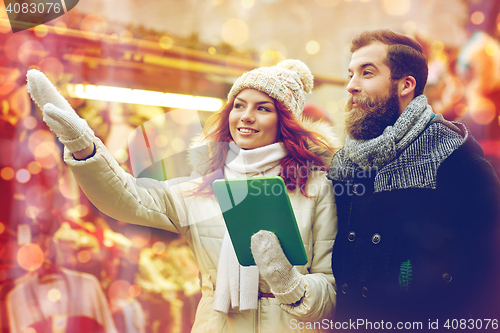 Image of happy couple walking with tablet pc in old town