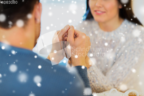 Image of happy couple holding hands at restaurant or cafe