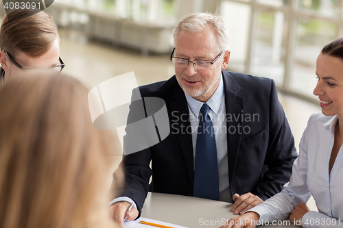 Image of smiling business people meeting in office