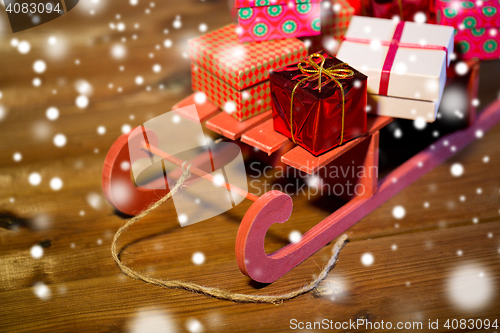 Image of close up of christmas gift boxes on wooden sleigh