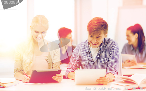 Image of two smiling students with tablet pc at school