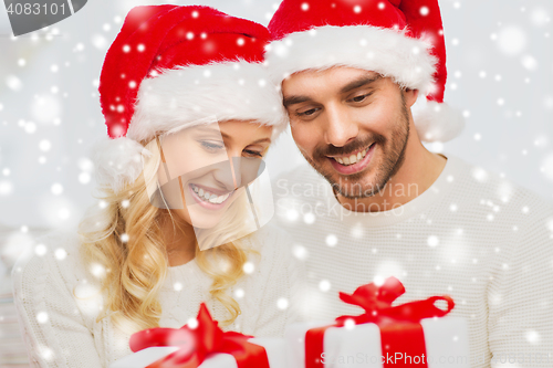 Image of happy couple at home with christmas gift boxes