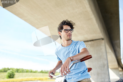 Image of young hipster man riding fixed gear bike