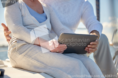 Image of senior couple with tablet pc on sail boat or yacht