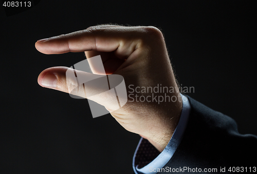 Image of close up of businessman hand showing small size