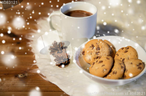 Image of cups of hot chocolate with cookies on fur rug