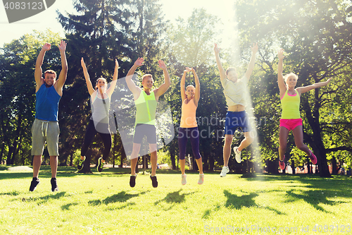 Image of group of happy friends jumping high outdoors