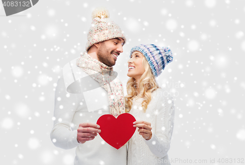 Image of smiling couple in winter clothes with red heart