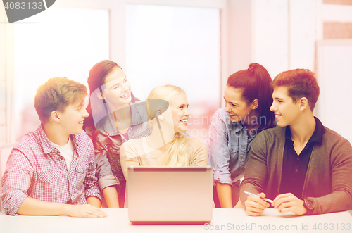 Image of smiling students with laptop at school