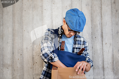 Image of hipster man looking for something in his bag