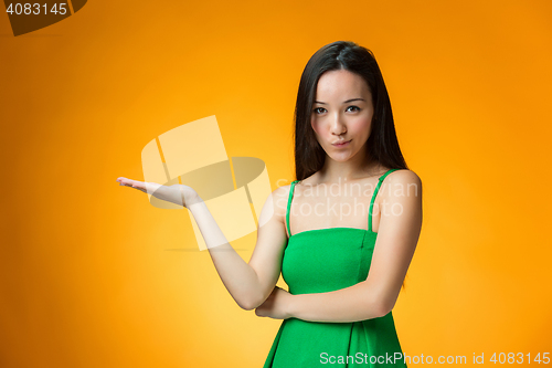 Image of The happy Chinese girl on yellow background