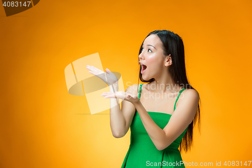Image of The happy Chinese girl on yellow background