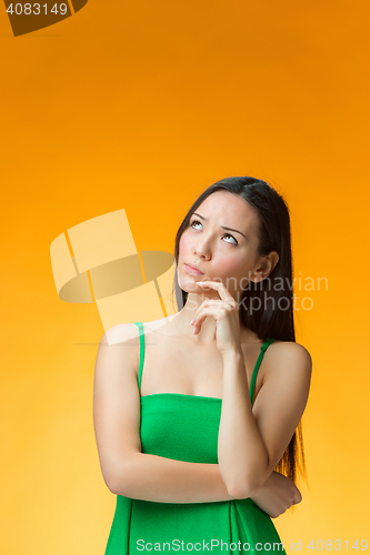 Image of The thinking Chinese girl on yellow background