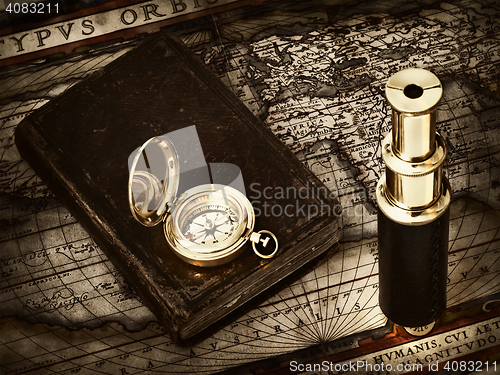 Image of vintage telescope and compass at antique map