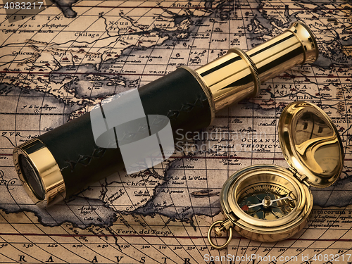 Image of vintage telescope and compass at antique map