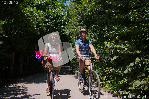 Image of Young multiethnic couple having a bike ride in nature