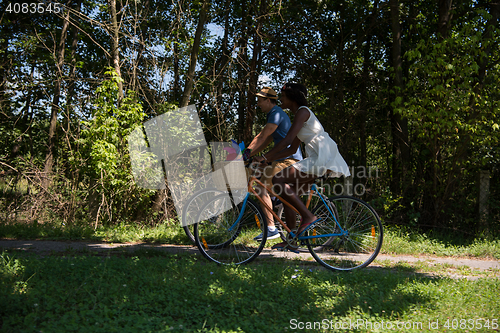 Image of Young multiethnic couple having a bike ride in nature