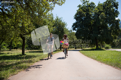 Image of Young multiethnic couple having a bike ride in nature