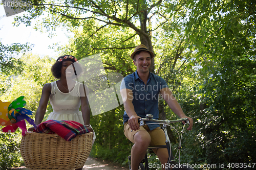 Image of Young multiethnic couple having a bike ride in nature
