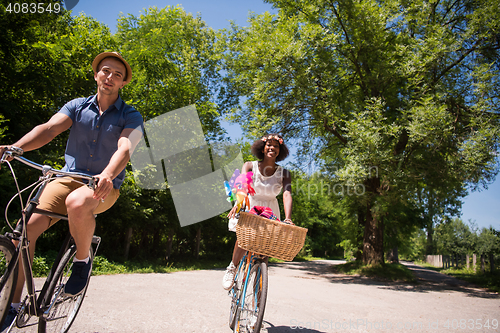 Image of Young multiethnic couple having a bike ride in nature