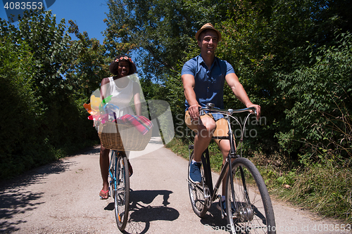 Image of Young multiethnic couple having a bike ride in nature