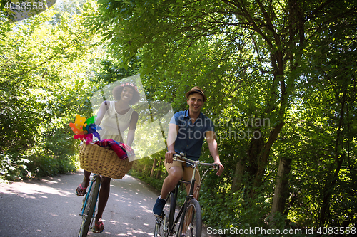 Image of Young multiethnic couple having a bike ride in nature