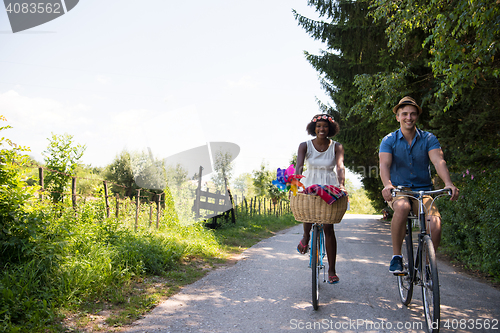 Image of Young multiethnic couple having a bike ride in nature