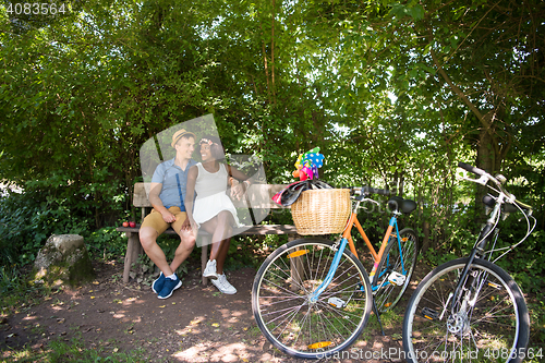 Image of Young multiethnic couple having a bike ride in nature