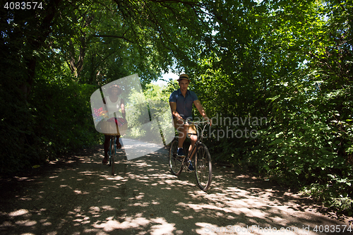 Image of Young multiethnic couple having a bike ride in nature