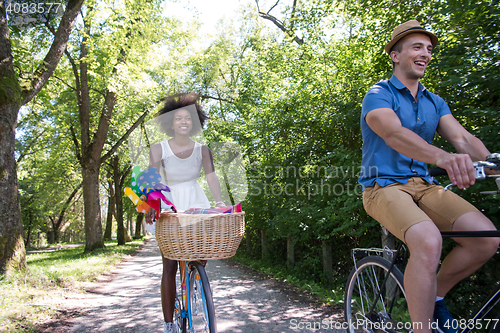 Image of Young multiethnic couple having a bike ride in nature