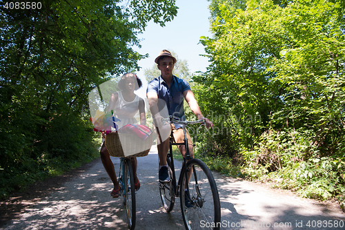 Image of Young multiethnic couple having a bike ride in nature