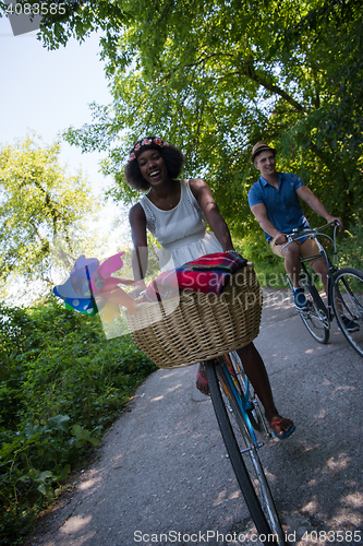 Image of Young multiethnic couple having a bike ride in nature