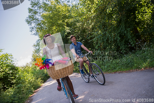 Image of Young multiethnic couple having a bike ride in nature